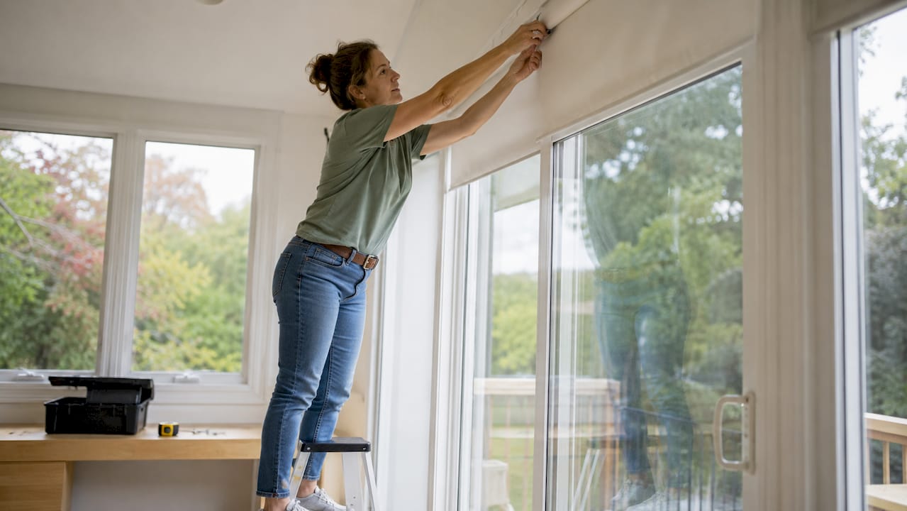 Homeowner installing blackout roller shade