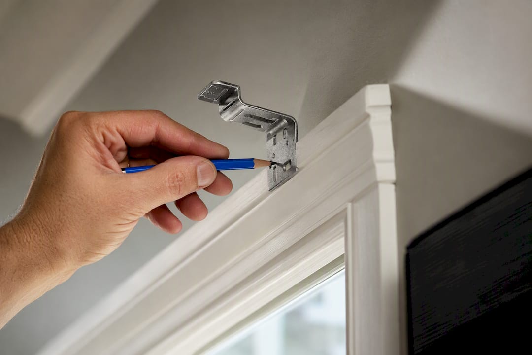 Bracket positioned above painted window trim