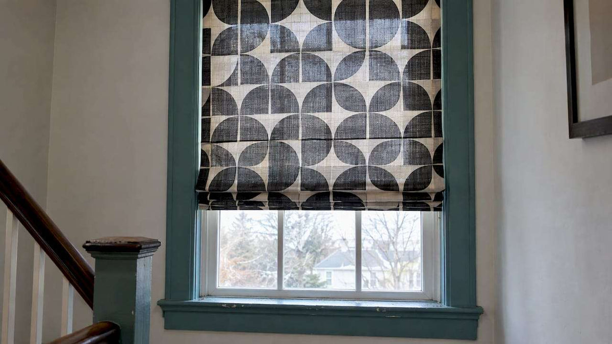 Geometric Shades Are Trending with a black, gray, and cream geometric fabric shade featuring repeating circles and arcs