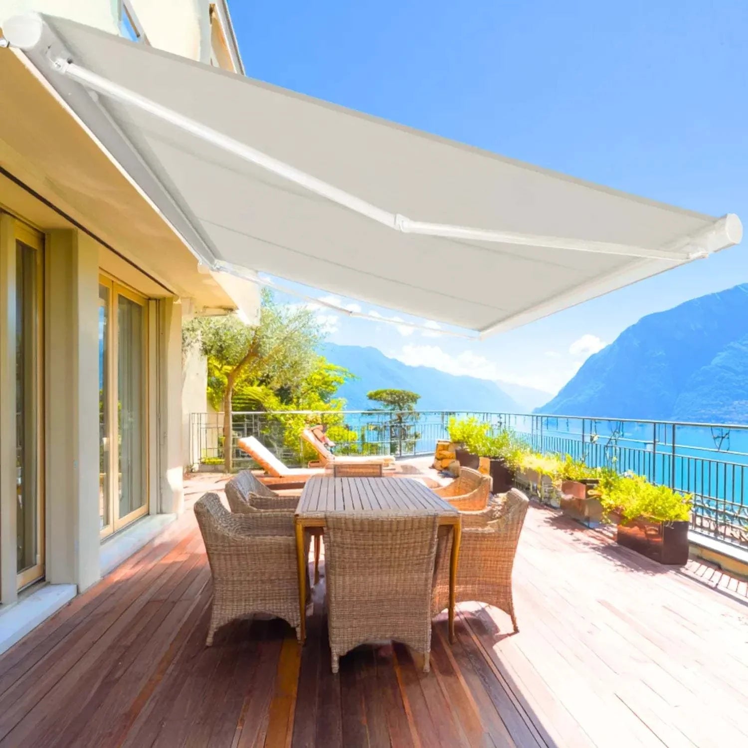 Value Blinds® motorized retractable awning on patio with outdoor dining set and mountain view
