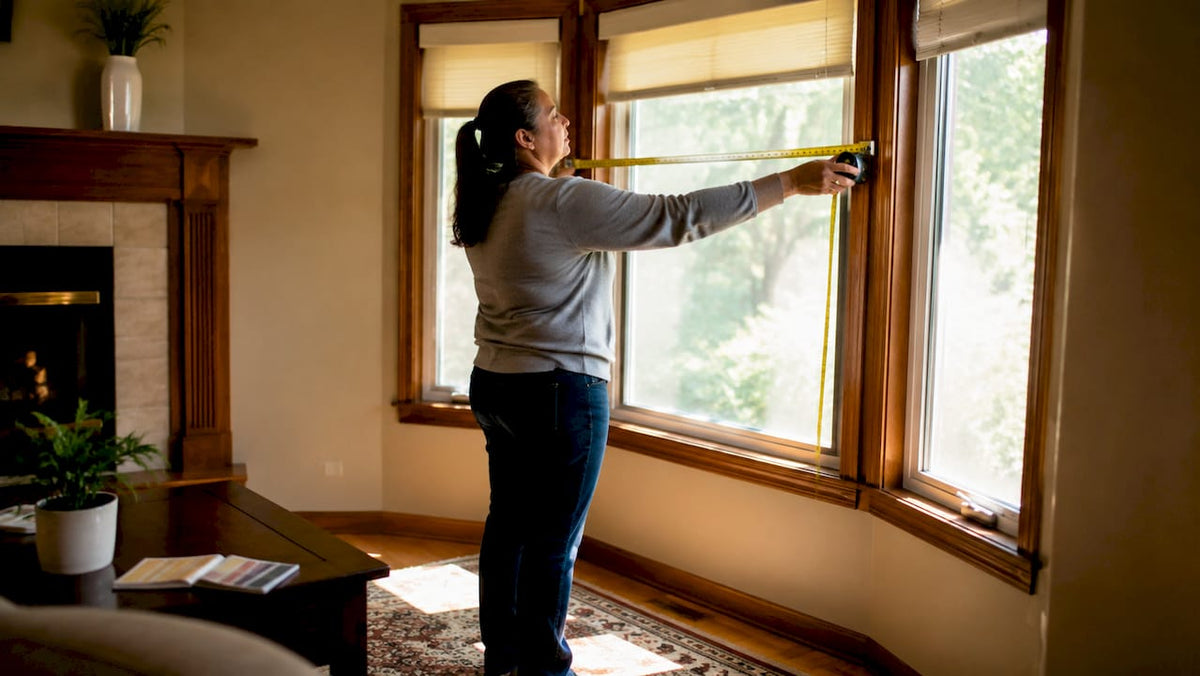 Woman measuring window width for vertical blinds