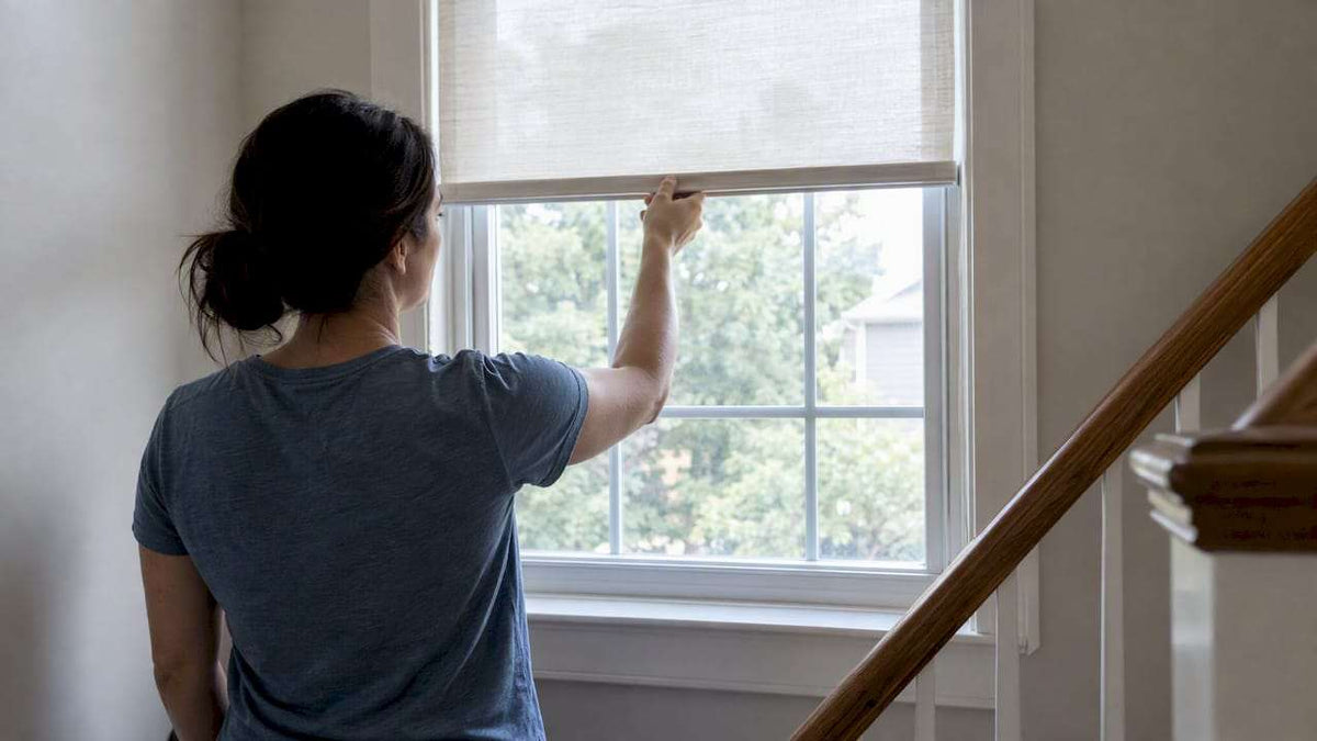 Homeowner raising a cordless window shade