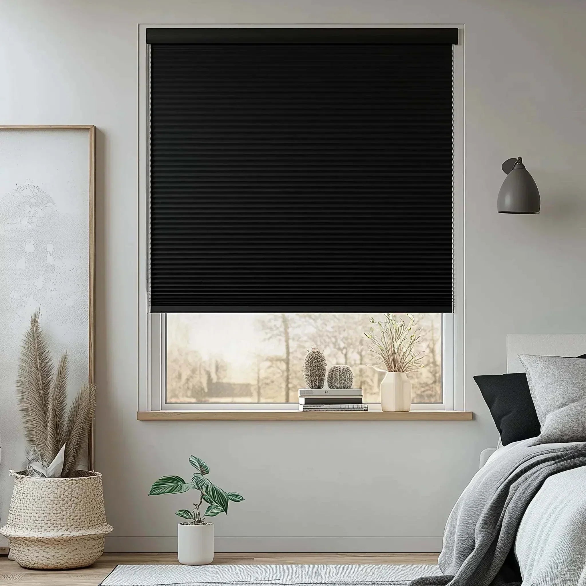 Cordless blackout cellular shades in black honeycomb design covering a modern bedroom window with minimalist decor